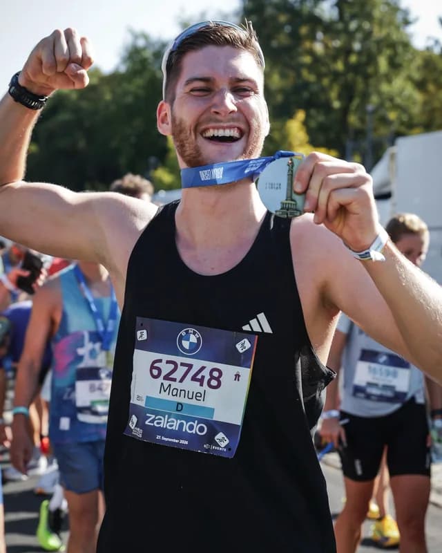 Manuel mit Medaille und Startnummer im Ziel des Berlin-Marathons
